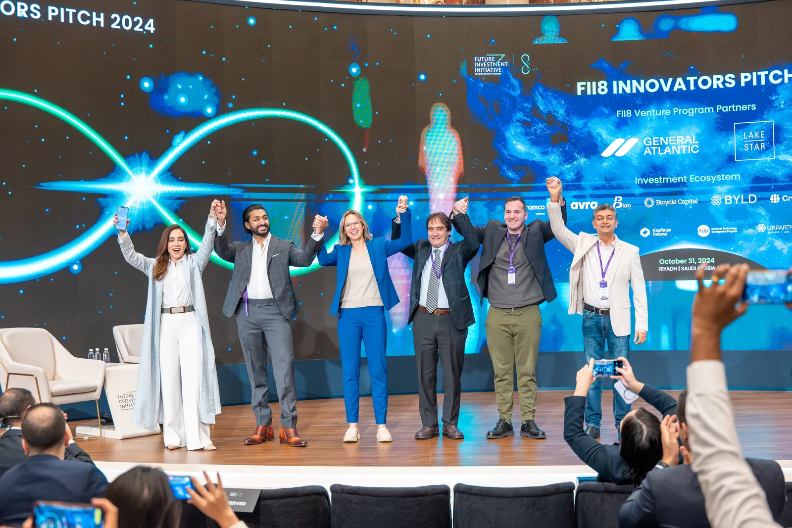 FII8 Innovators Pitch 2024 finalists celebrate together on stage.